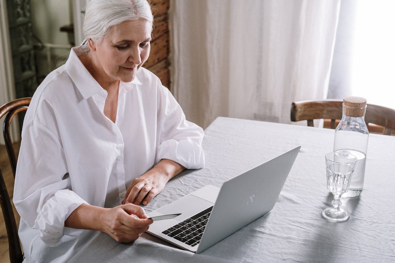 Seniorin am Laptop Altenpflege im Digitalzeitalter – zwischen Menschlichkeit und Innovation